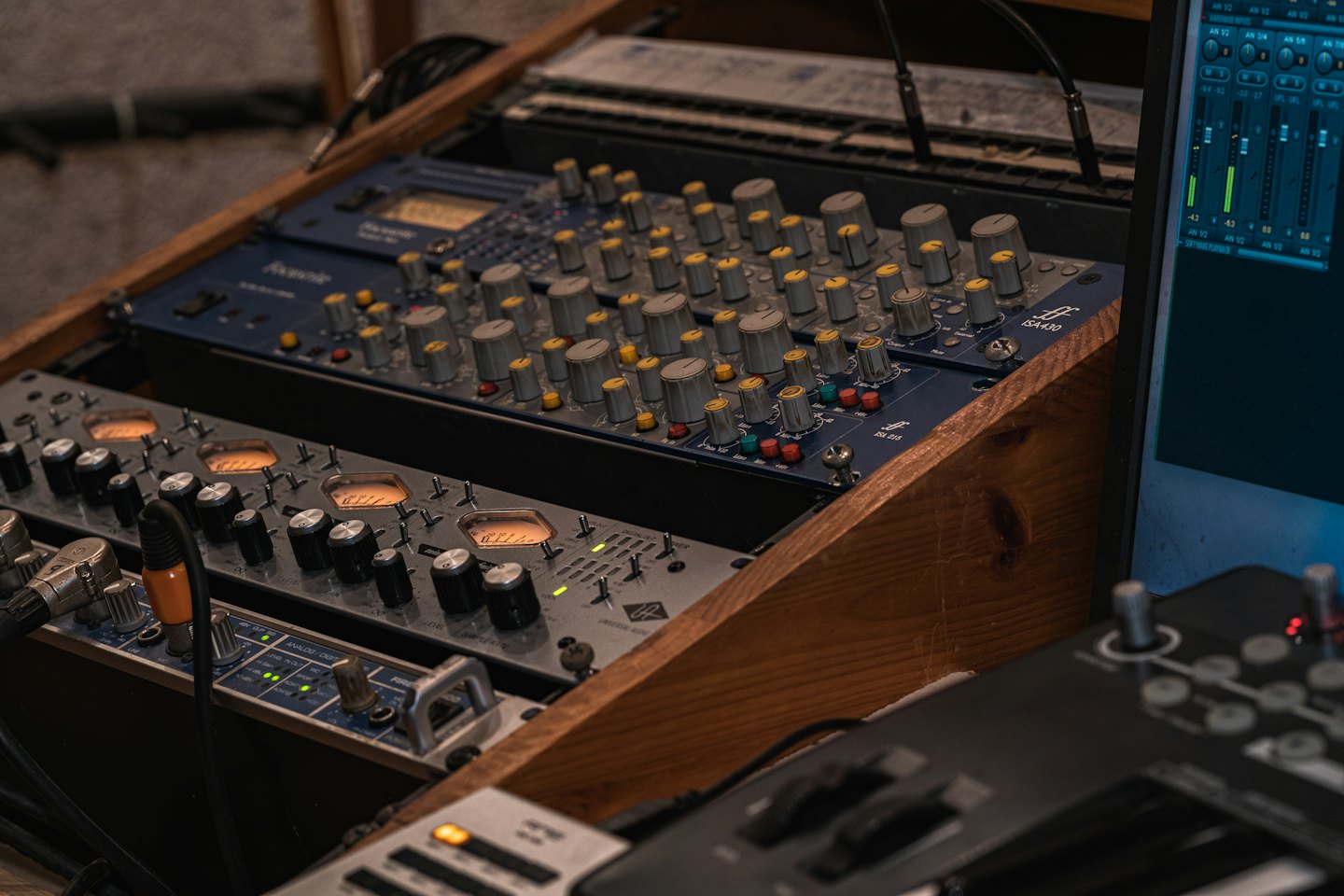 Apparecchiature professionali per il missaggio audio all'interno di un rack di legno.